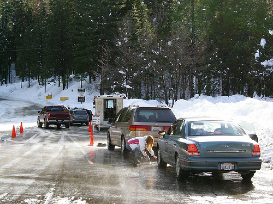 Trip photo #21/77 A Tire Chain salesvan and lady putting on chains near Yosemite Park Entrance